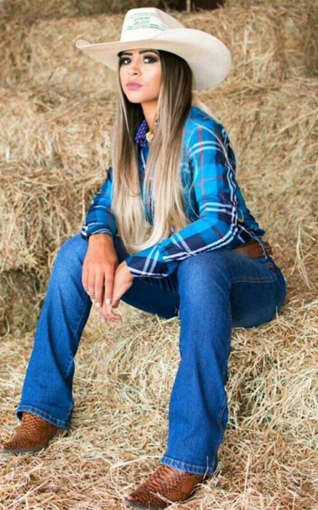 Uma mulher vestindo roupas de cowgirl, com um chapéu de cowboy e botas de couro, simbolizando a moda country.