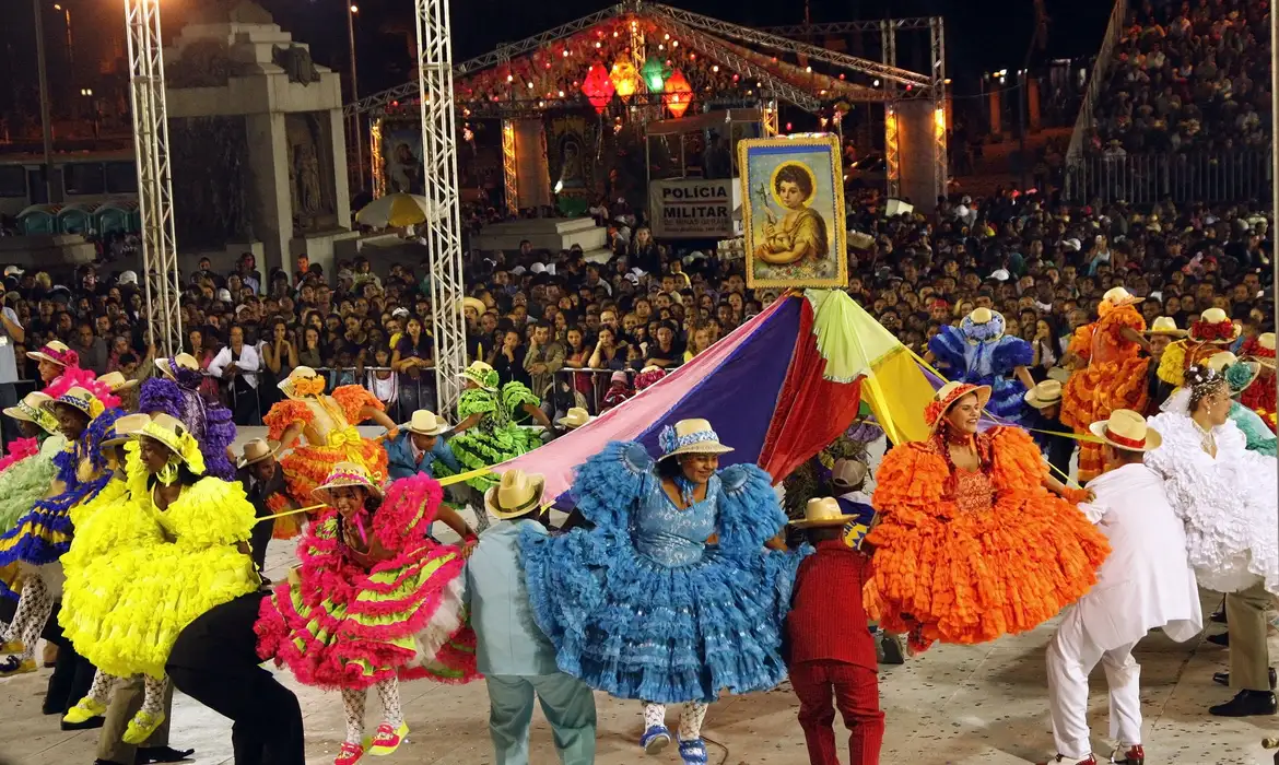 Festas Juninas no Campo com bandeirinhas e pessoas dançando quadrilha