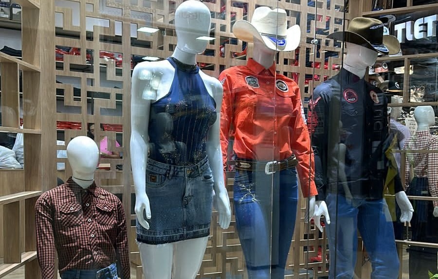 Grupo de pessoas vestindo roupas típicas country em um evento rural