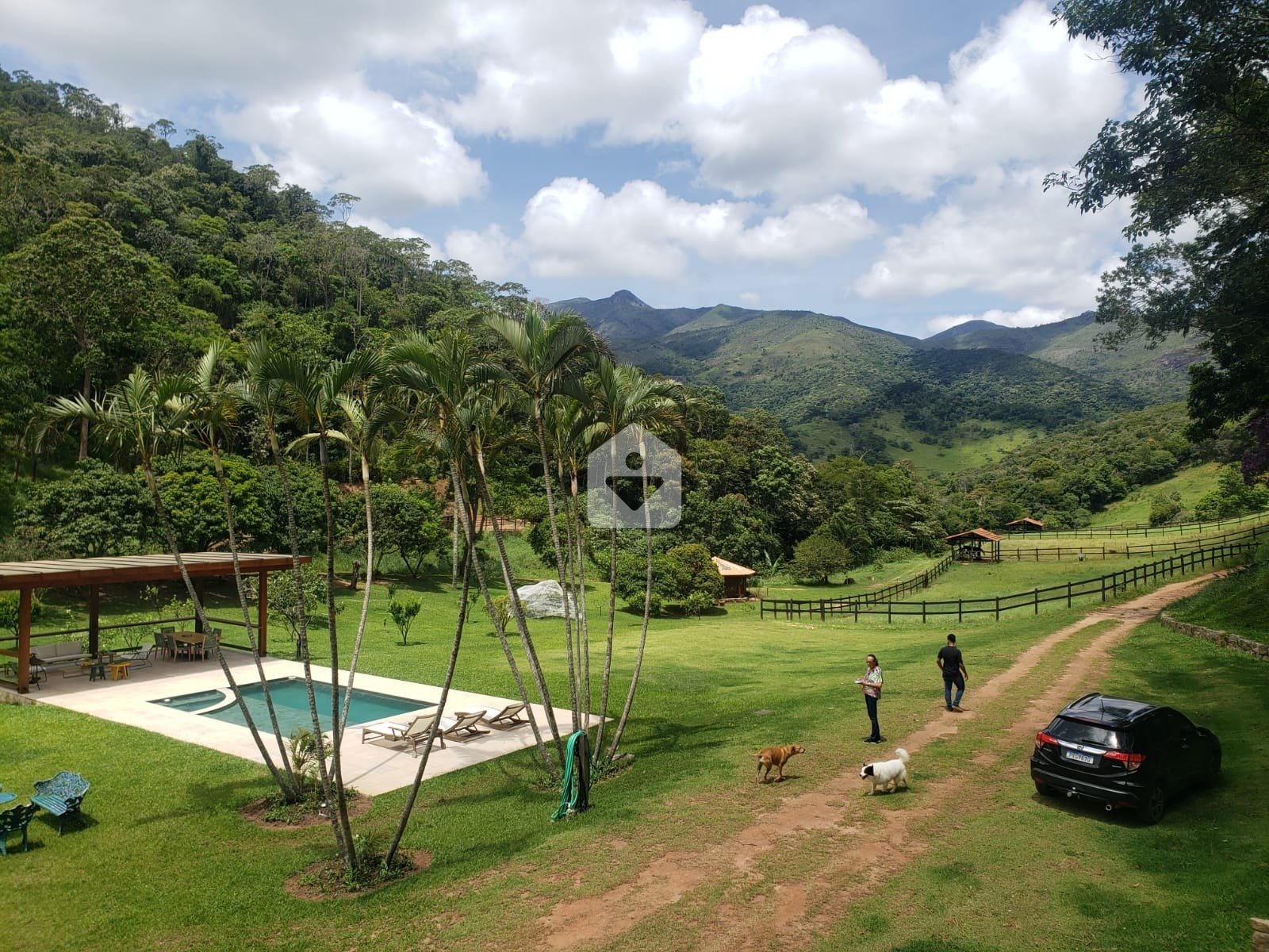 Uma paisagem rural serena, com uma fazenda ao fundo e vacas pastando em um campo verdejante sob um céu azul, simbolizando o estilo de vida country.