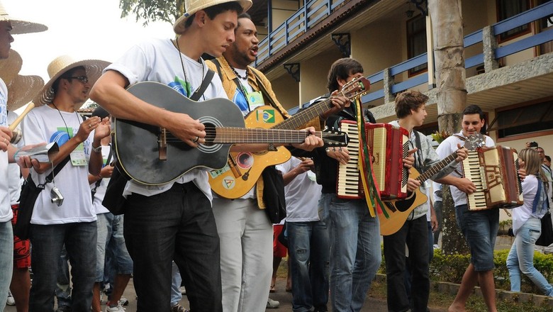 Jovens discutindo a cultura rural brasileira em um ambiente ao ar livre, com elementos que remetem ao campo e à tradição country.