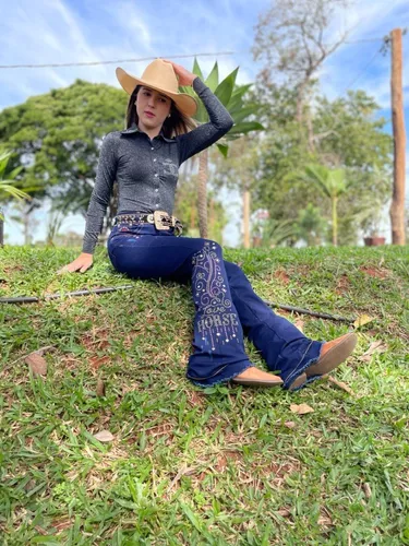 Mulher com vestido country e chapéu em um campo exuberante