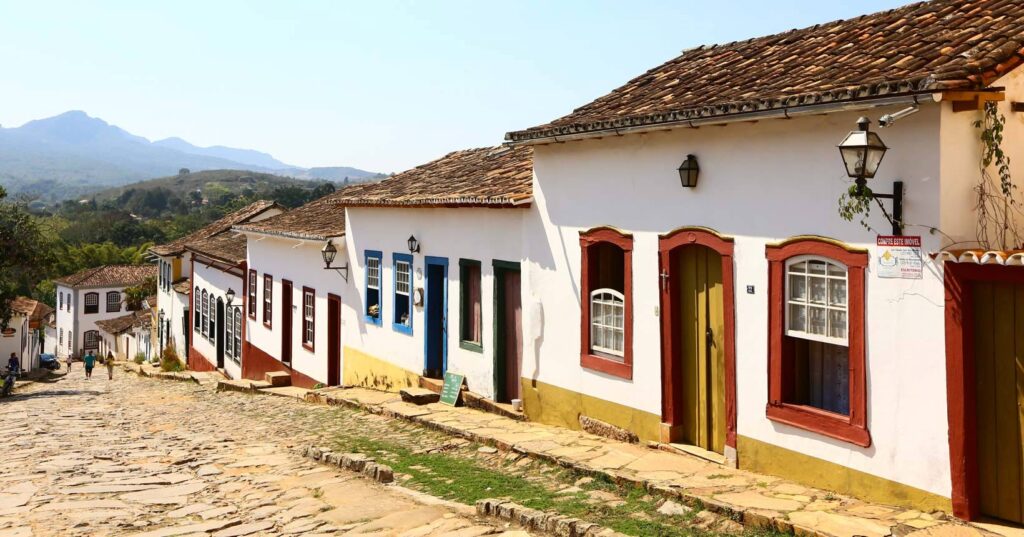 Cenário rural mineiro com montanhas e fazendas típicas do interior de Minas Gerais.