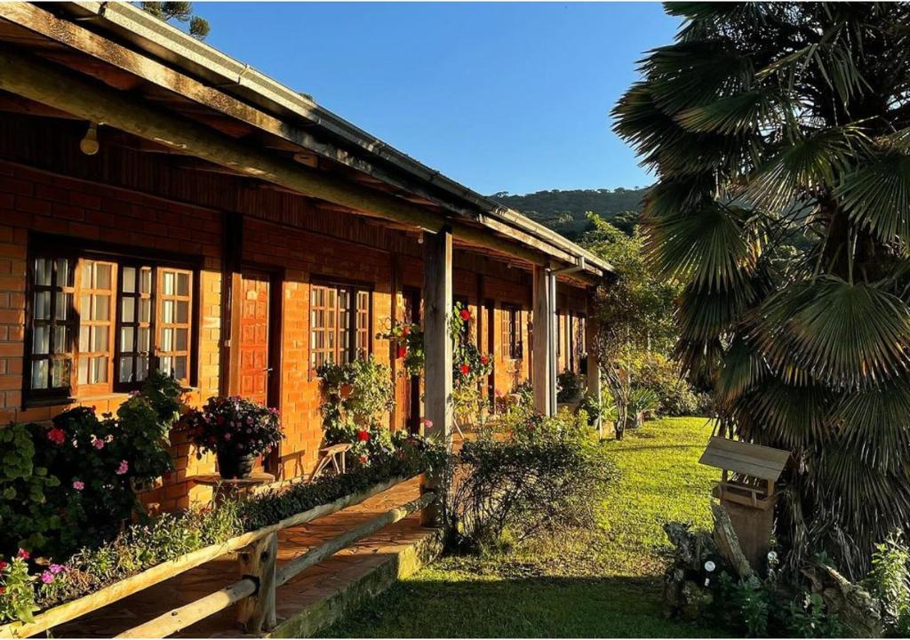 Um lindo dia ensolarado em uma fazenda de turismo rural, rodeada por campos verdes e árvores, com uma cabana rústica ao fundo.