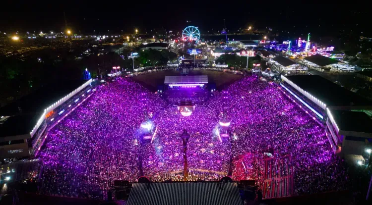 Festa do Peão mostrando montaria em touro em uma arena repleta de pessoas