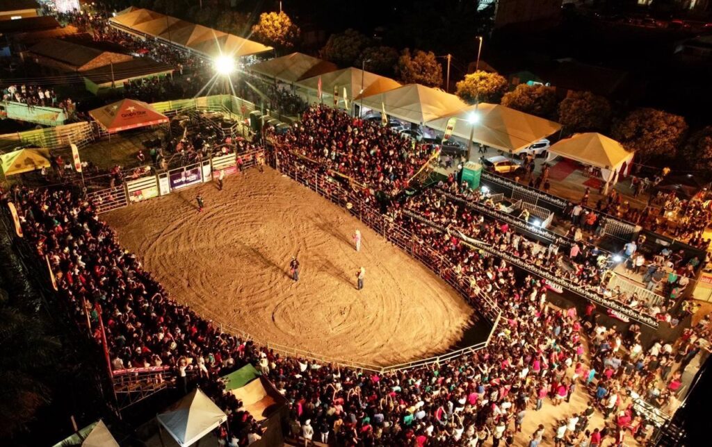 Competidores em um rodeio brasileiro demonstrando habilidades em montaria e laço.