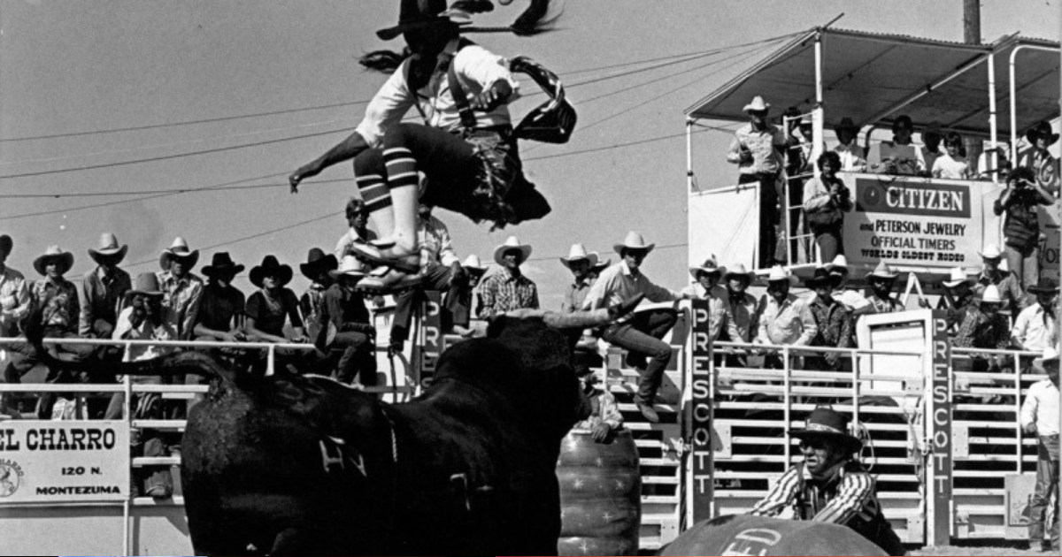 Imagem mostrando um rodeio no Brasil, com cowboys montando em touros em uma arena cercada por espectadores.