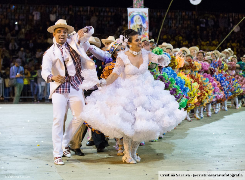 Participantes de um tradicional baile country em Minas Gerais, dançando em trajes típicos.