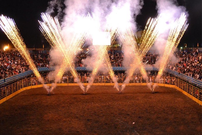 Competição de rodeio com cowboys em ação