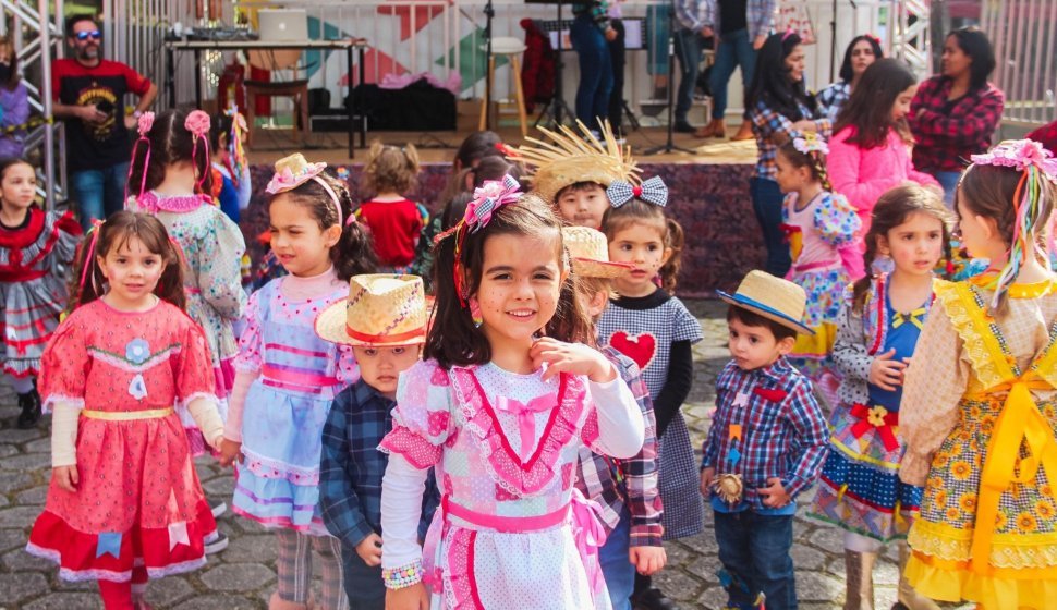 Festa Junina com bandeirinhas coloridas, fogueira e pessoas dançando