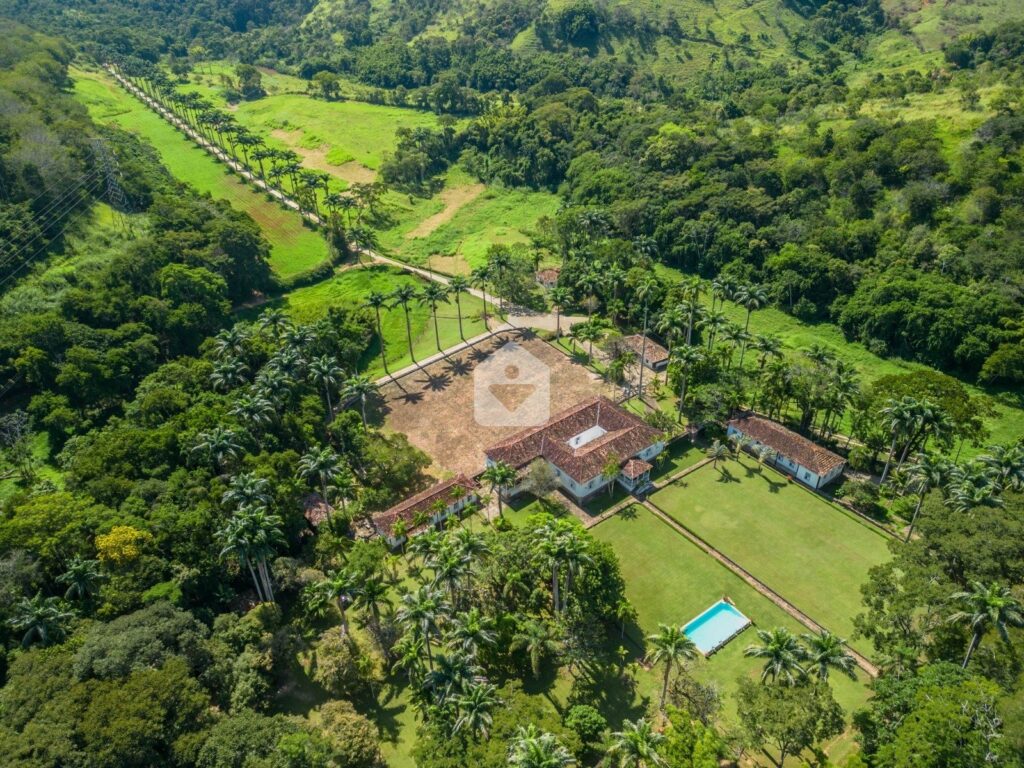 Uma linda paisagem rural na Região Serrana do Rio, com campos verdes e montanhas ao fundo