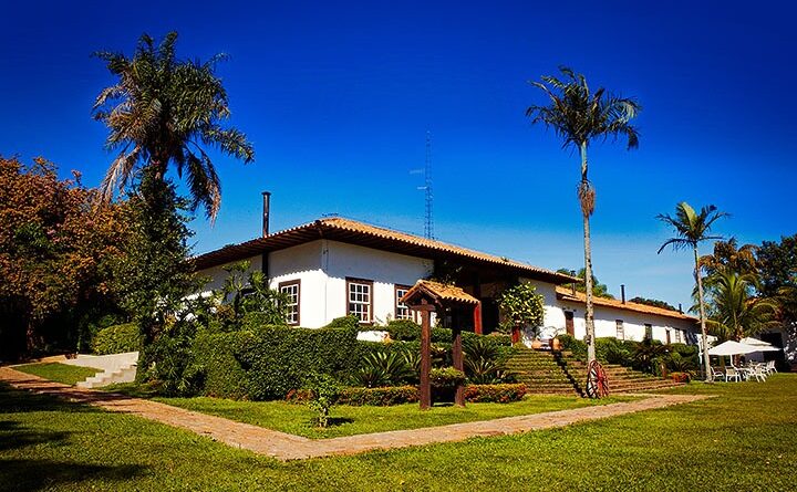 Um belo campo com fazenda ao fundo, destacando a beleza rural e a experiência do turismo no campo.