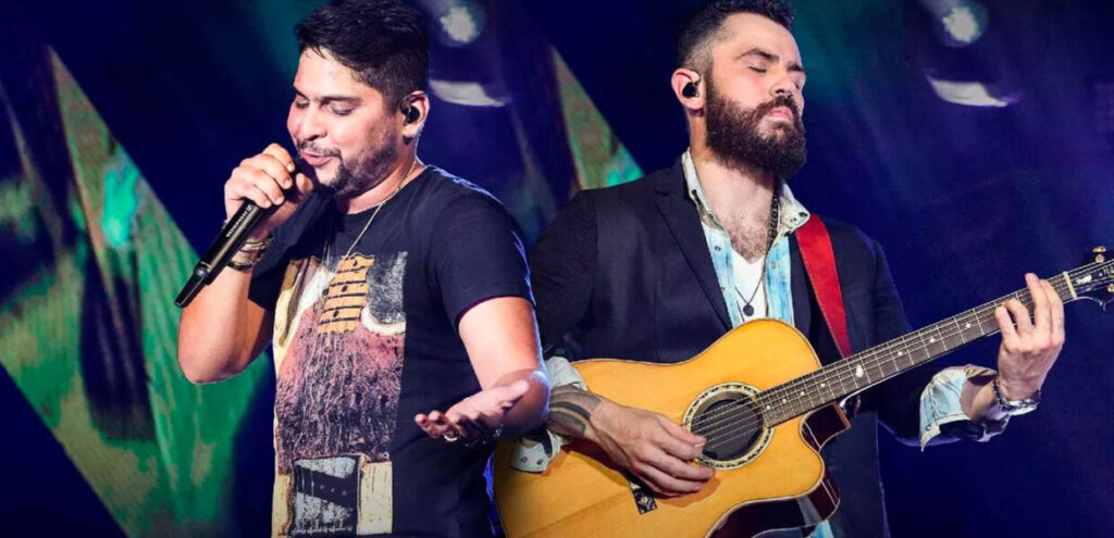 Imagem representativa do Sertanejo Universitário, com músicos tocando violões em um ambiente festivo.