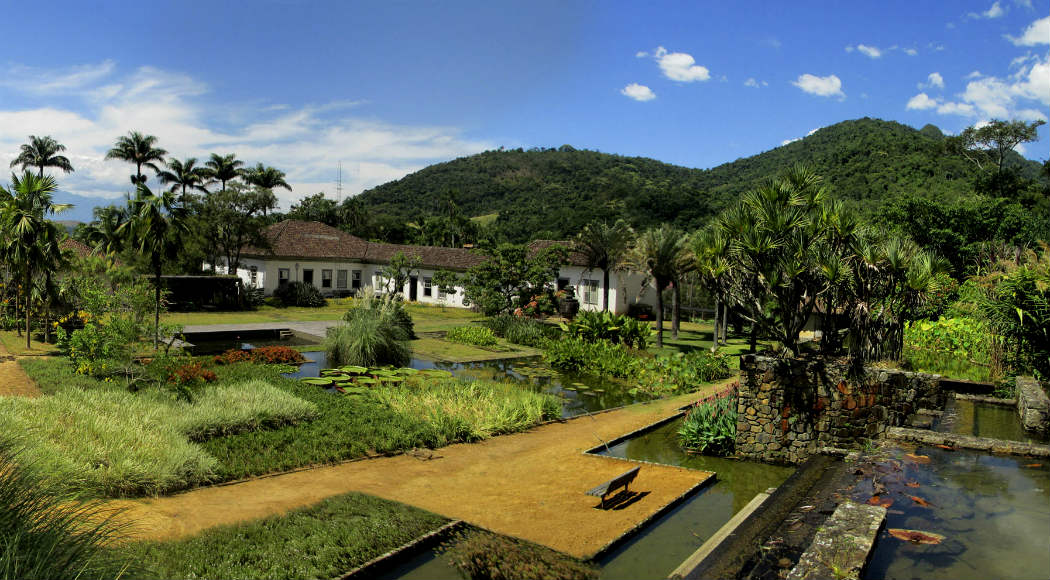 Fazenda histórica com arquitetura colonial e áreas verdes exuberantes