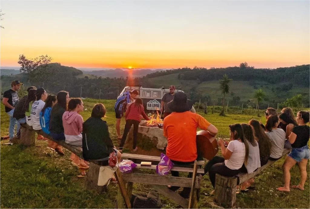 Paisagem rural do sul do Brasil com pastores e gado ao pôr do sol, refletindo a essência do ecoturismo e do turismo rural.