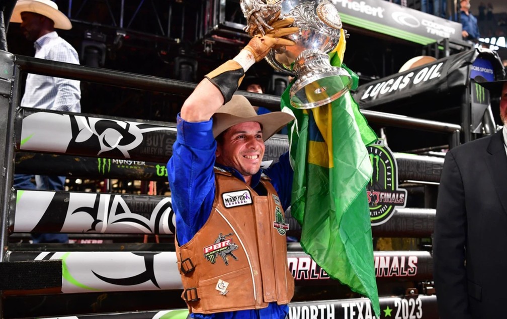 Peão sendo recebido com festa após conquistar título de campeão mundial de rodeio em evento na zona rural do Brasil.
