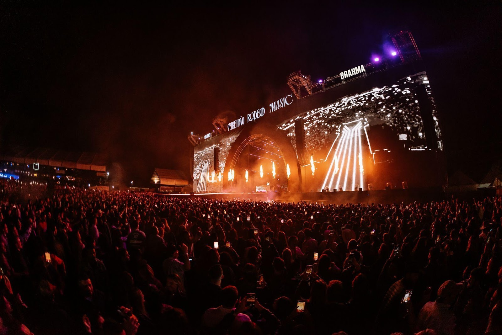 Um show sertanejo vibrante com artistas no palco e uma plateia animada