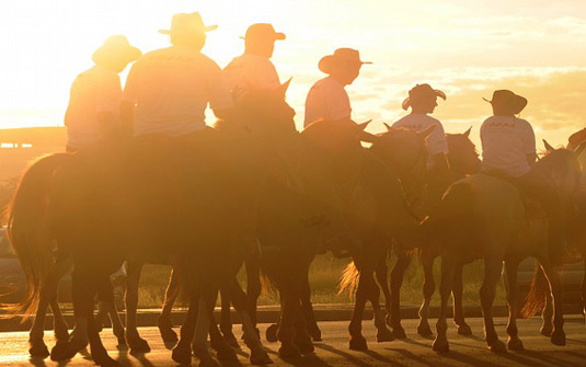 Cavaleiros e amazonas participando de uma cavalgada em Brasília, demonstrando a tradição country.