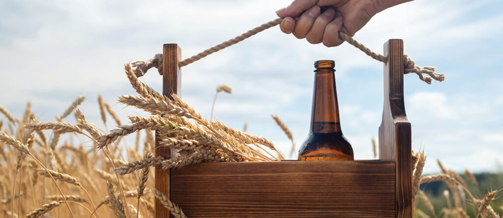 Cervejas artesanais rurais em um ambiente country, com campos verdes e madeira rústica ao fundo.