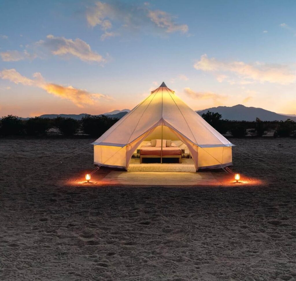 Acampamento no campo com tendas e natureza ao redor