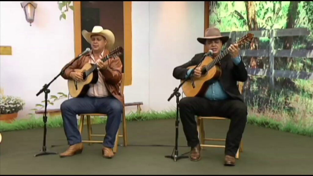 Duplas sertanejas se apresentando com violas em um cenário rural.