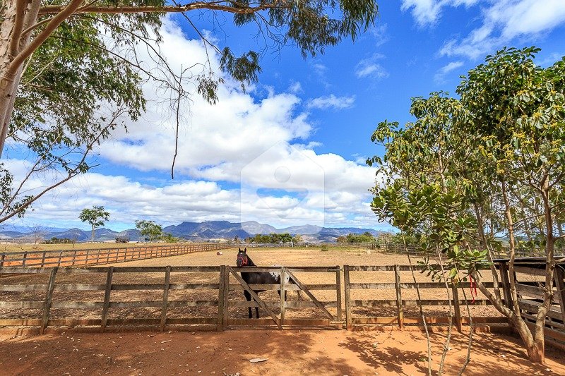Fazenda country com campos verdejantes e céu azul