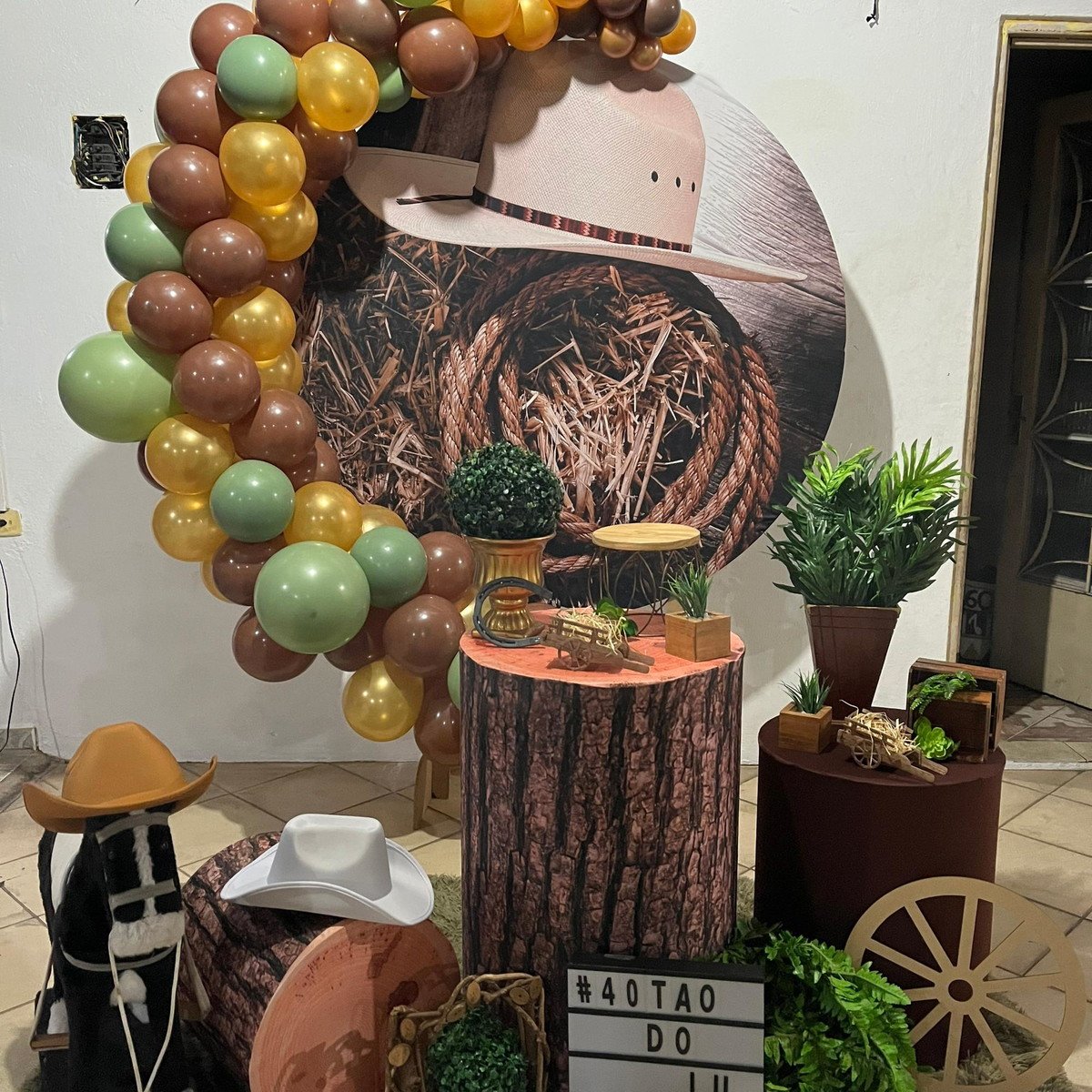 Mesa decorada para festa country com elementos rústicos e itens típicos do cowboy.