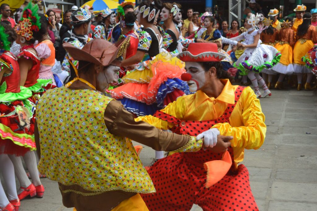 Uma celebração das tradições do interior com pessoas dançando em um evento ao ar livre.