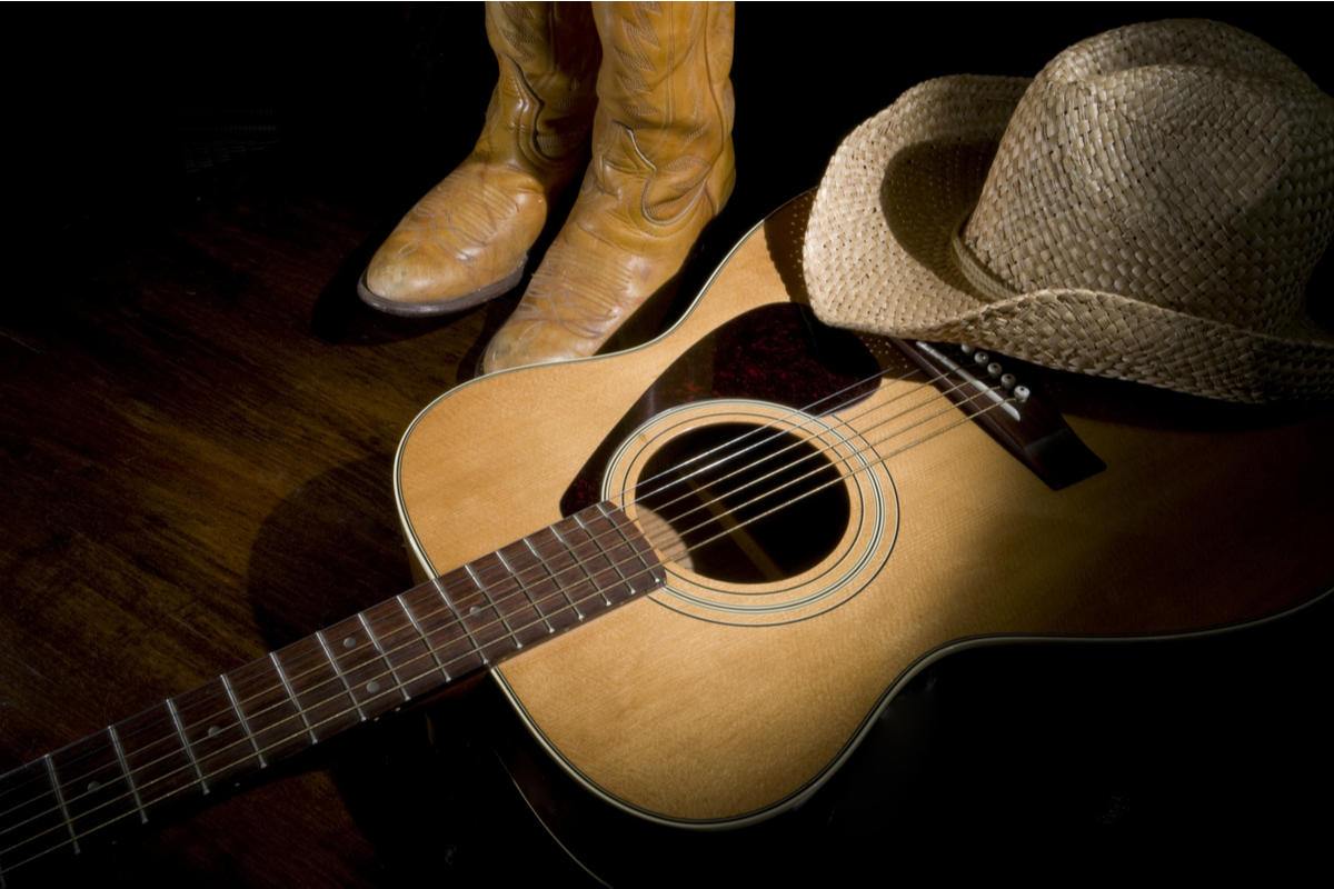 Uma representação da música sertaneja, com elementos típicos como violas, chapéus de cowboy e uma paisagem rural ao fundo.