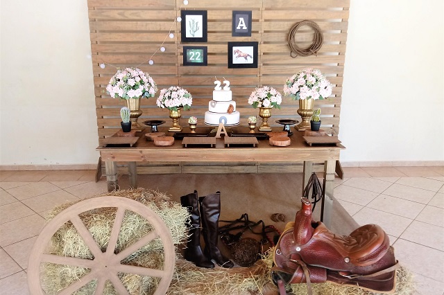 Decoração rústica de festa country com lanternas, flores silvestres e mesas de madeira.
