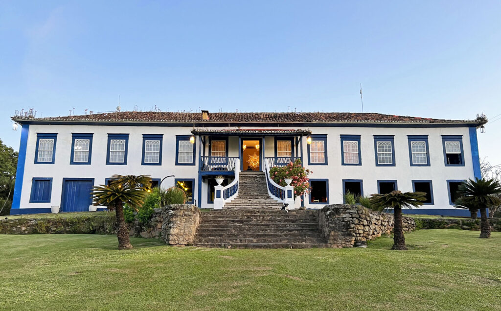 Fazenda histórica no Brasil com arquitetura colonial e paisagens rurais ao fundo, representando a cultura country.