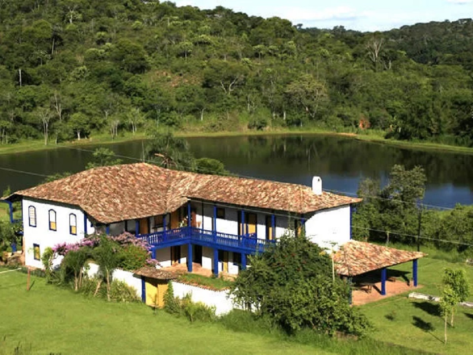 Paisagem rural de Minas Gerais com pastagens verdes e montanhas ao fundo, representando a vida campestre.