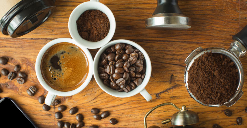 Grãos de café torrados em uma mesa rústica, evocando a essência do campo e o sabor caseiro.