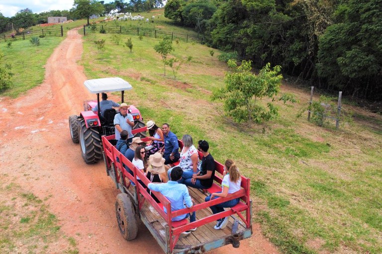 Uma linda paisagem rural com um celeiro vermelho e pastagens verdes sob um céu azul.