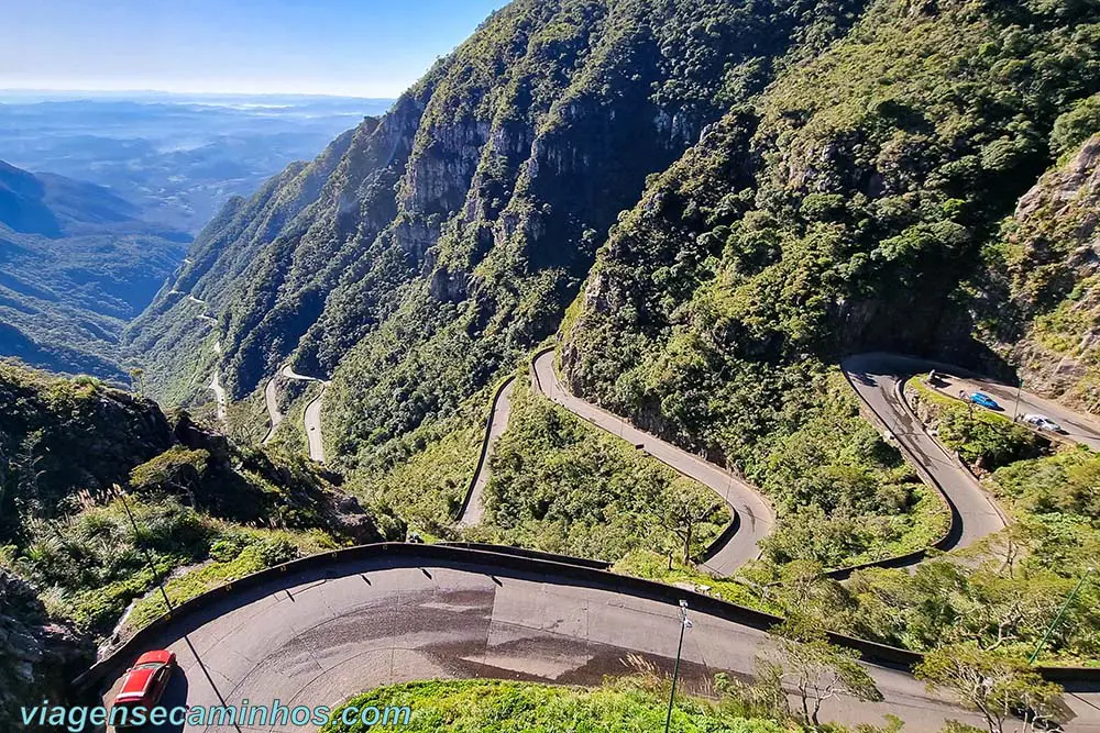 Estrada de terra na Serra do Rio do Rastro, cercada por paisagens rurais e montanhas.