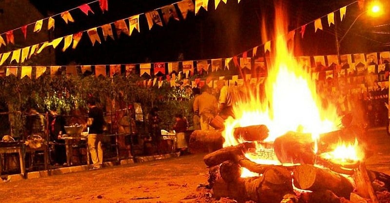 Celebração das Festas Juninas, com bandeirinhas coloridas e dançarinos vestidos de roupas tradicionais country.