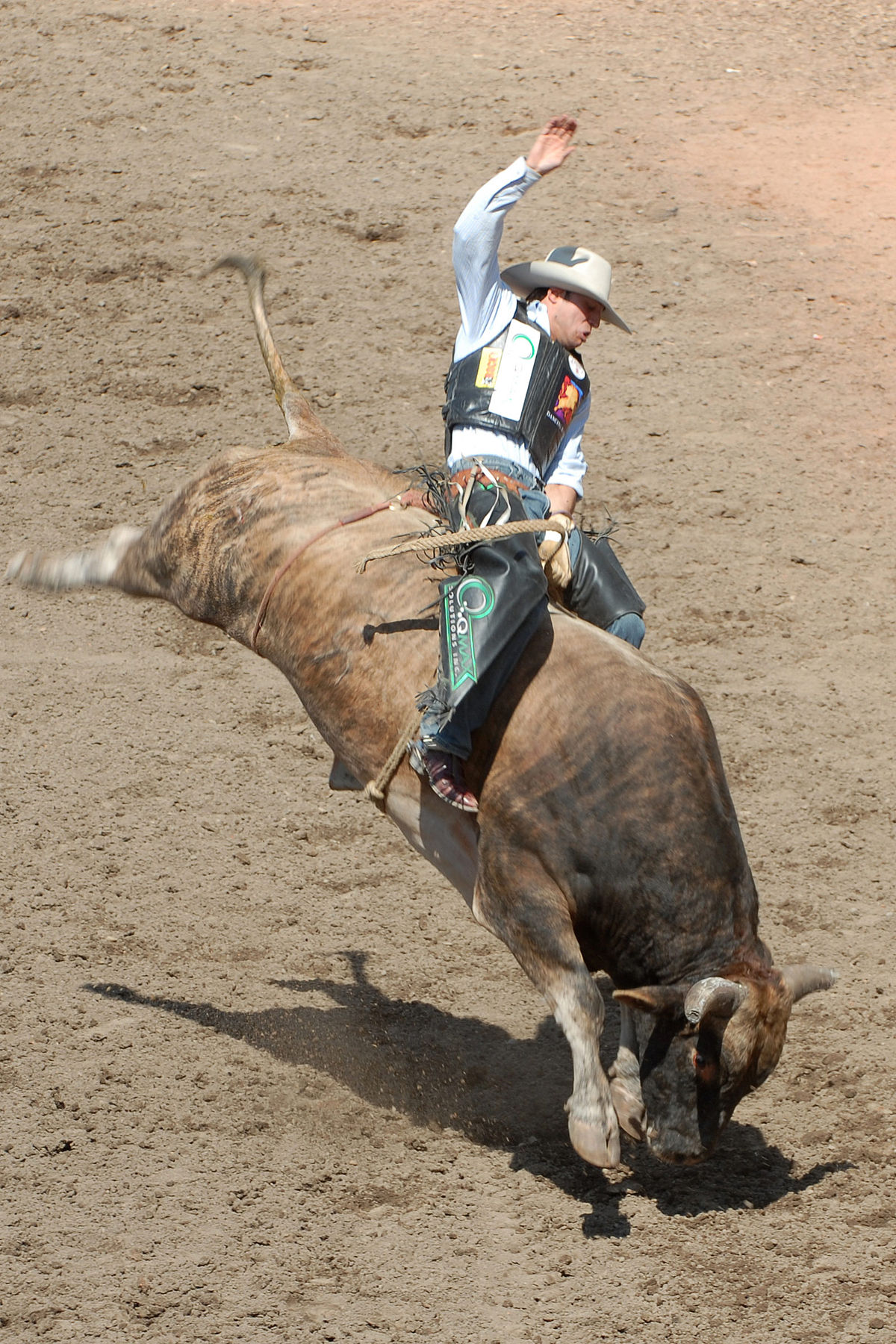 Imagem de um rodeio mostrando cavaleiros e touros em ação, destacando a cultura country