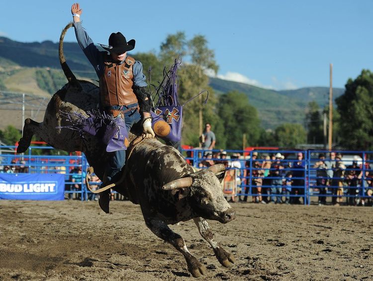 Cavaleiros competindo em um rodeio enquanto a plateia celebra a cultura sertaneja.