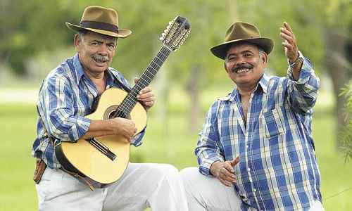 Músicos caipiras tocando violas em uma festa rural