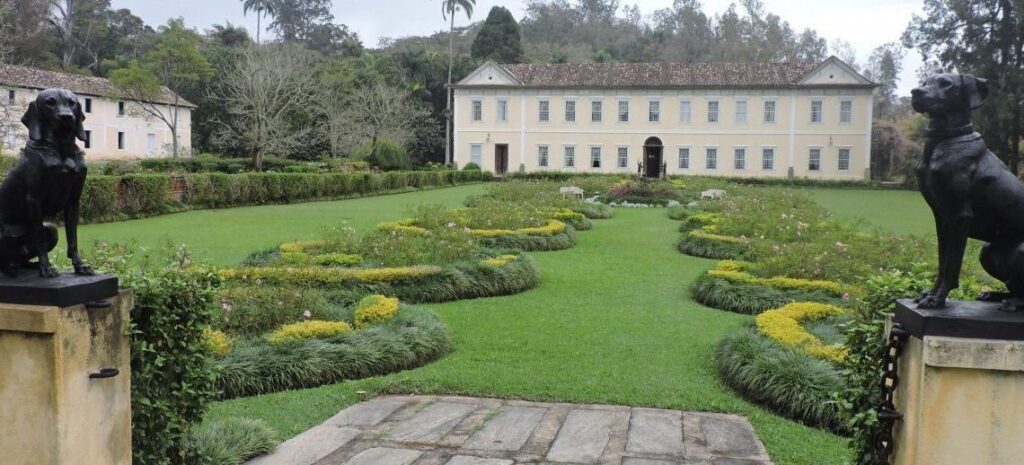 Uma fazenda de café cercada por belos campos verdes, típica do turismo rural.