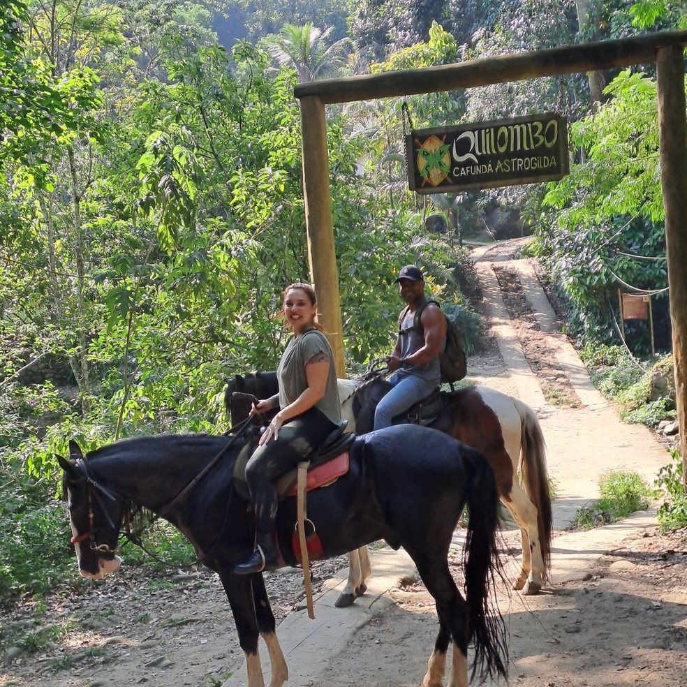 Cavalgadas em trilhas rurais sob um céu azul, com cavaleiros desfrutando da natureza.