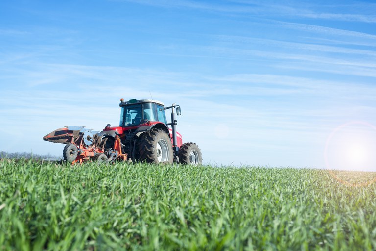 Tratores em um campo verde, simbolizando a agricultura moderna e a revolução no campo.