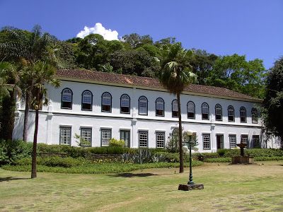 Uma fazenda histórica no Brasil com toques da arquitetura colonial e vastos campos verdes.