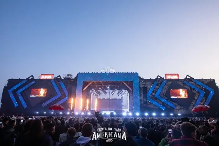 Festa do Peão de Americana 2025 com peões competindo em um rodeio e a plateia animada ao fundo.