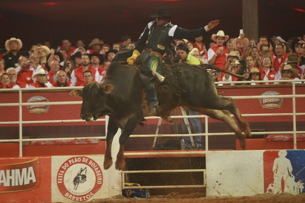 Boiadeiro em meio a uma festa de peão com cavalos e cowboys
