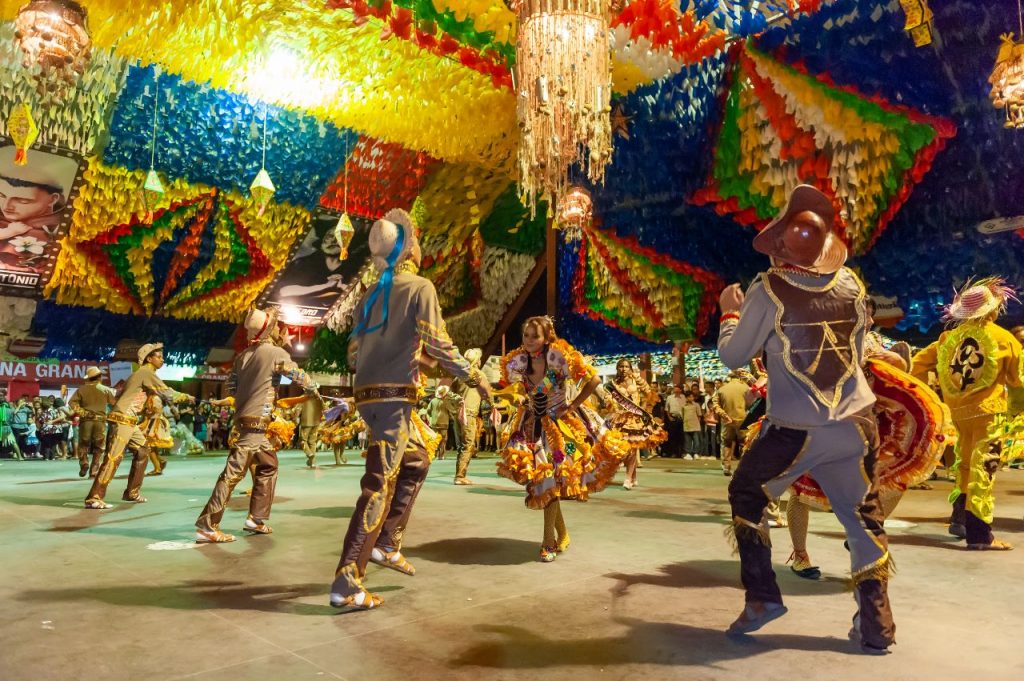 Um casal dançando quadrilha em uma festa junina, simbolizando as tradições do sertão.
