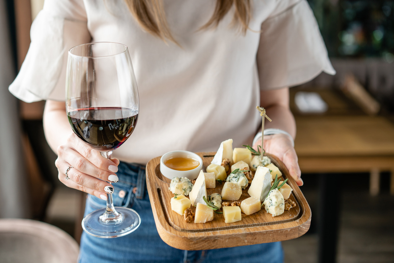 Uma bela tábua de queijos regionais harmonizada com vinhos do interior, ideal para um piquenique no campo.