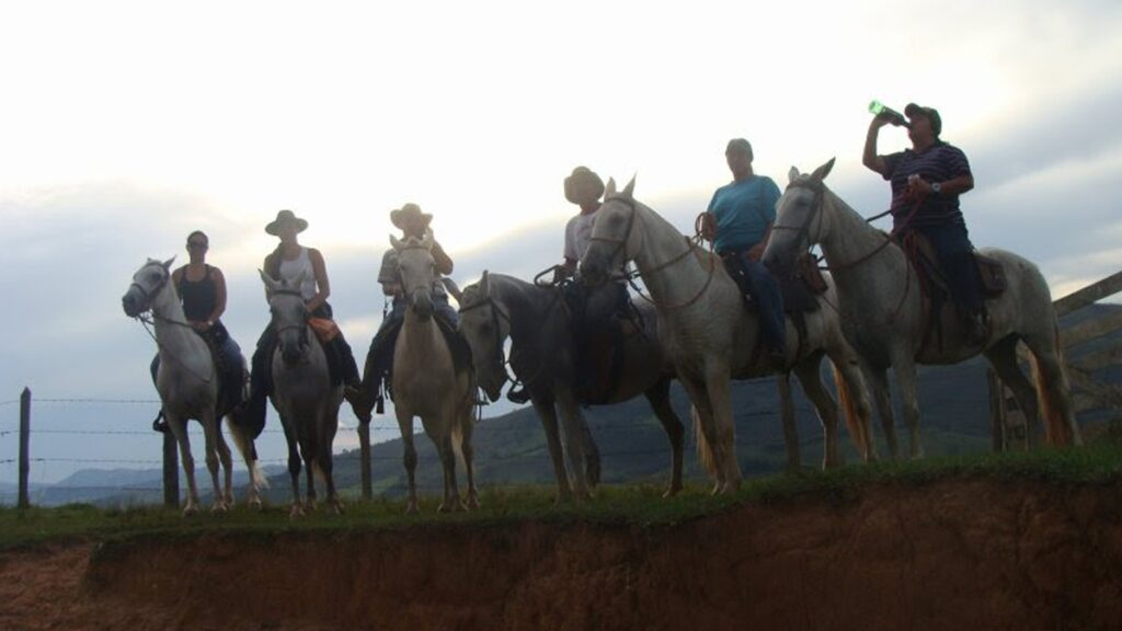 Cavalgadas em Minas Gerais, mostrando um grupo de cavaleiros explorando a natureza durante um passeio a cavalo.